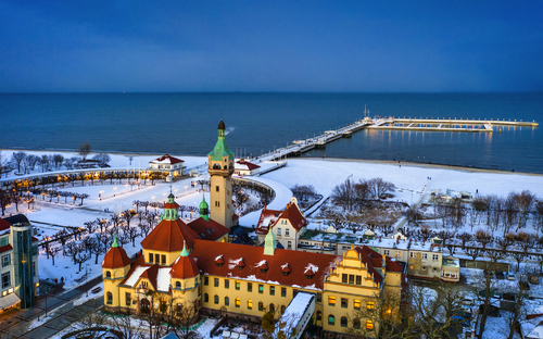 verschneiter Strand und Pier in Sopot in der Winterdämmerung